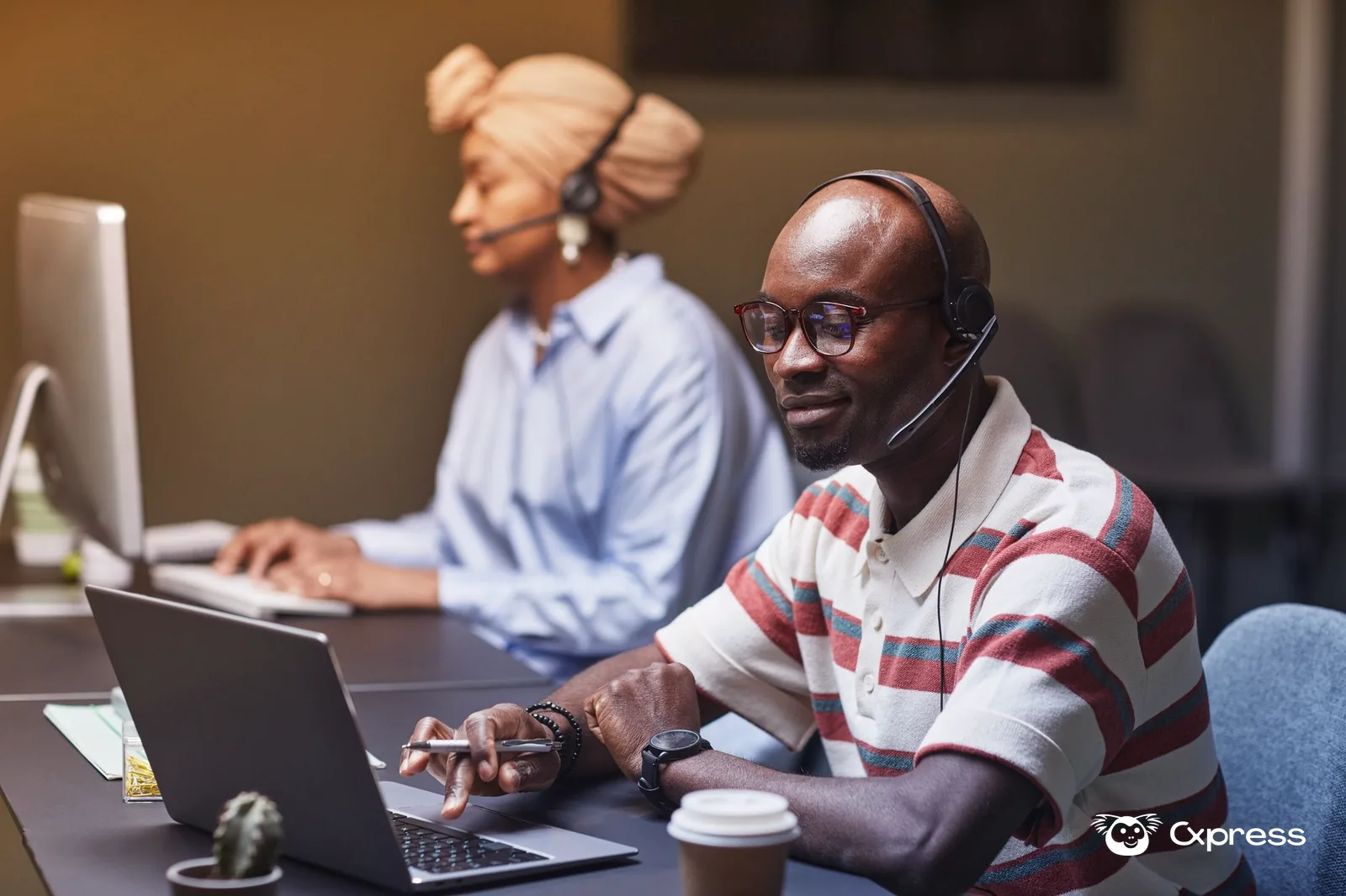 Agente de atención al cliente usando una computadora y audífonos para gestionar conversaciones digitales