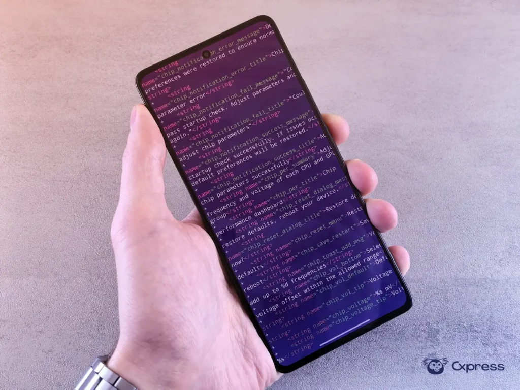 Persona revisando un código de autenticación en un celular junto a una computadora